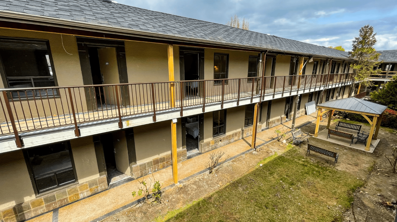 Exterior of Kingsway Supportive Housing featuring a gazebo and surrounding green space.