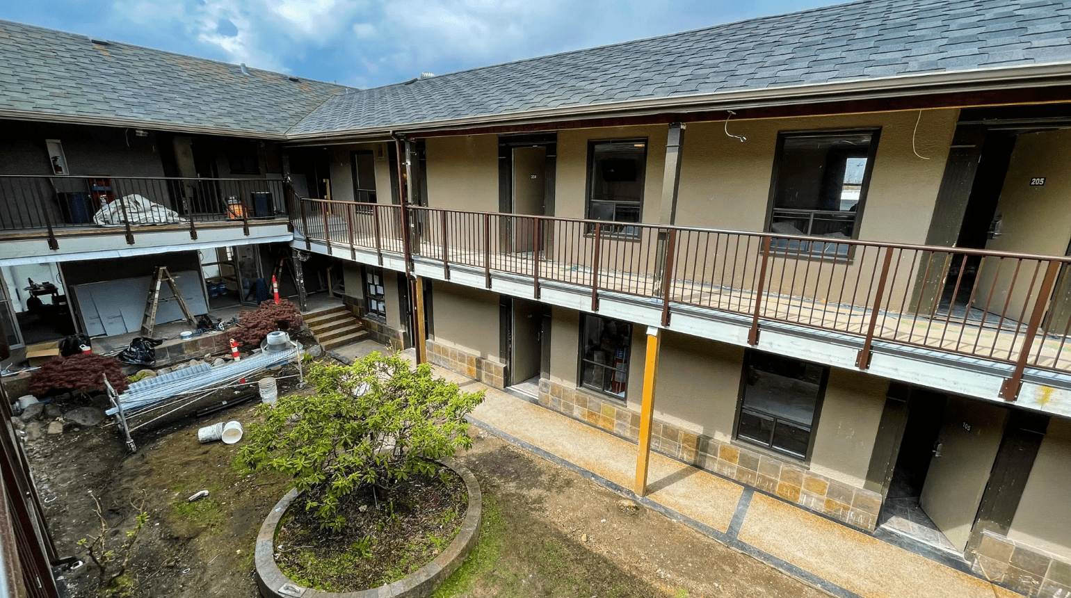 Small green outdoor space in the middle of Kingsway Supportive Housing, surrounded by the building