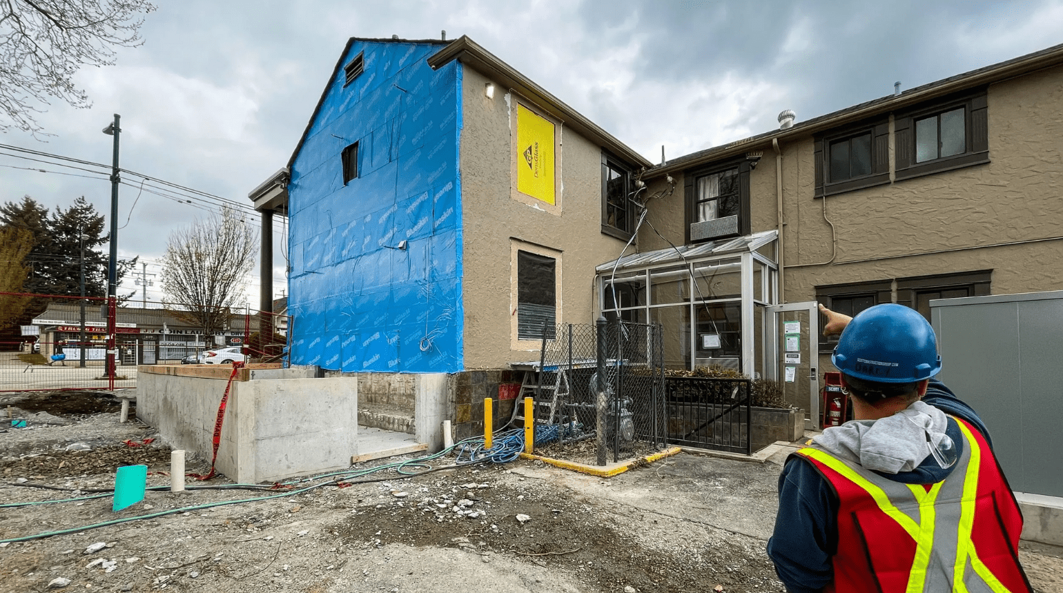 One person in a hard hat looking at the construction site at Kingsway Supportive Housing