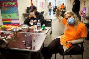 Connective staff and service user making decorations.