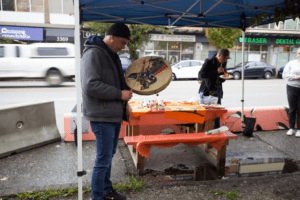 Man holding a traditional hand drum. 