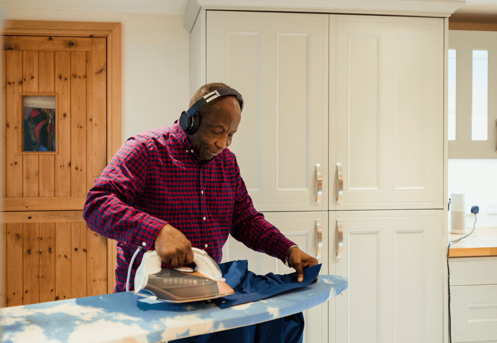 Man ironing and wearing headphones
