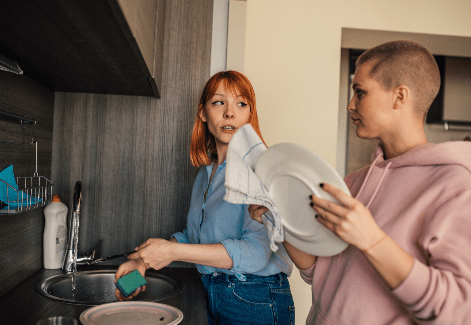 Two women washing dishes and talking