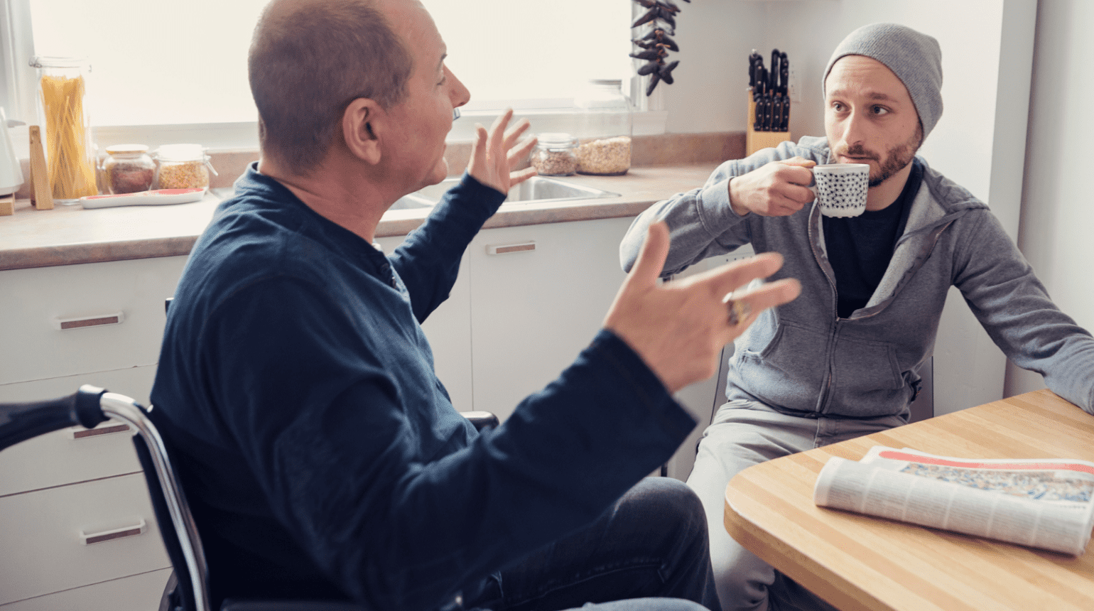 Two men talking in a kitchen