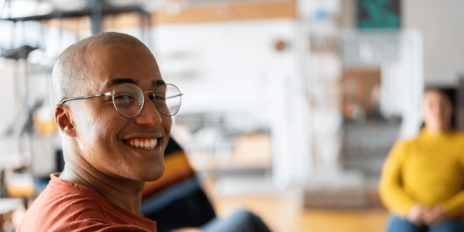 Man smiling with people in the background