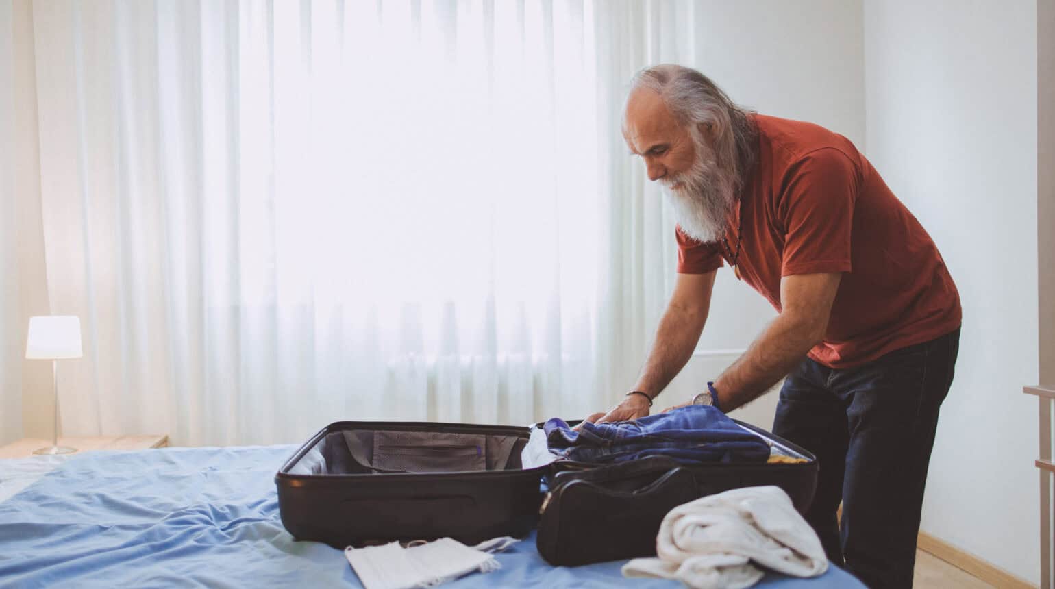 A mature man packing for a trip