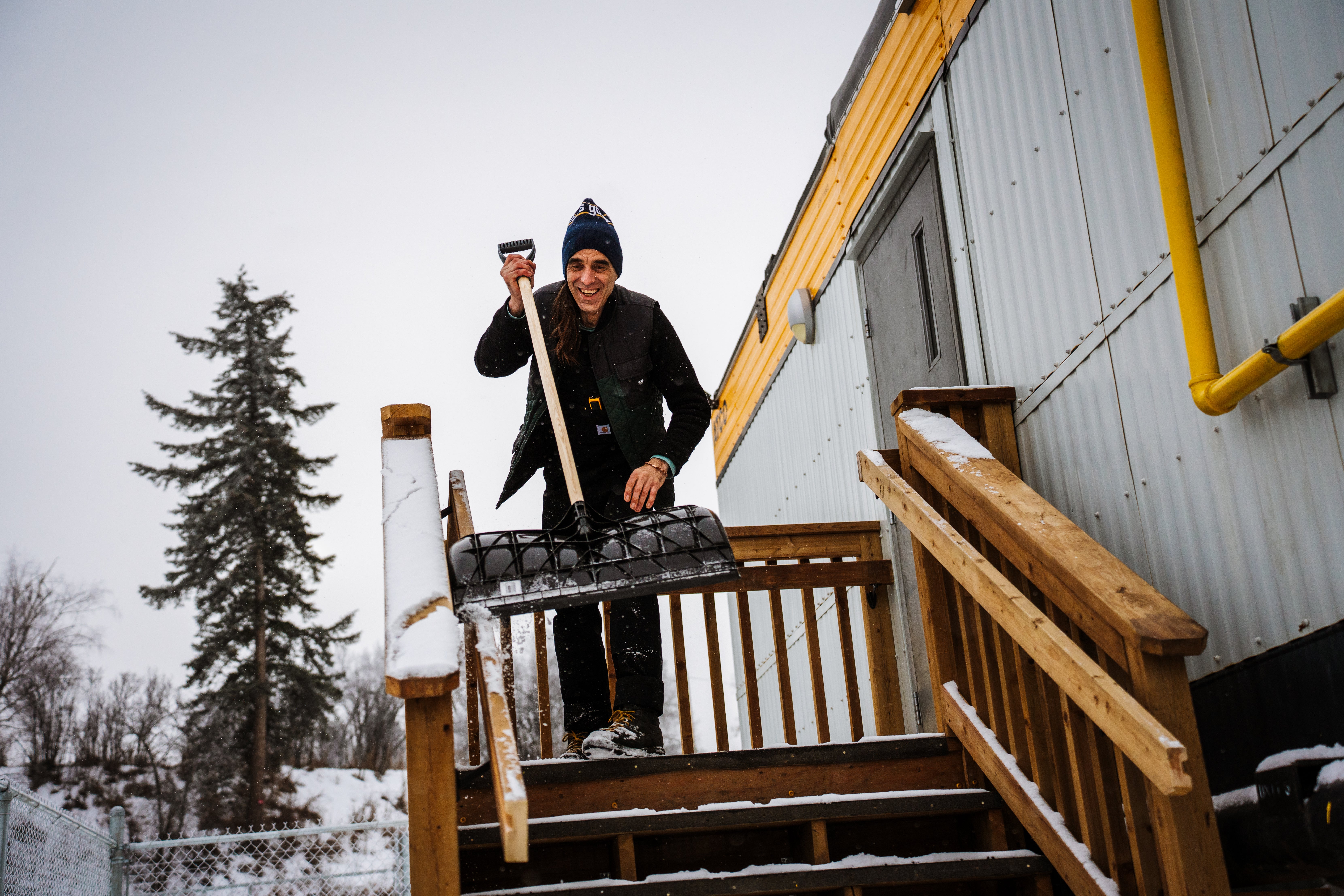 A man shoveling snow off their porch