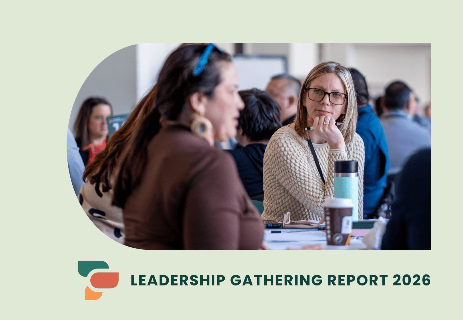 People participating in a leadership gathering, seated around tables and engaged in conversation.